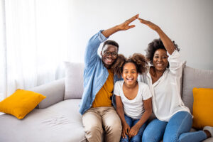 Happy family forming house roof with their hands at home. Insurance concept. Concept of housing and relocation. happy family mother father and kids with roof at home